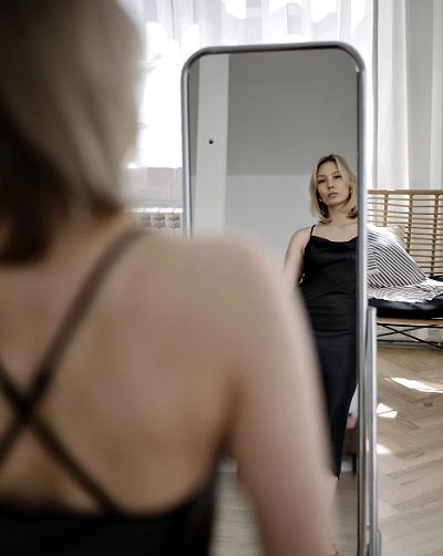 Woman looking in mirror to discover her hip shape #hipshape #bodytype https://www.style-yourself-confident.com/hip-shape.html